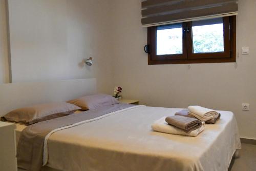 a bedroom with a bed with towels on it at Everlong Boutique Home in Nea Michaniona