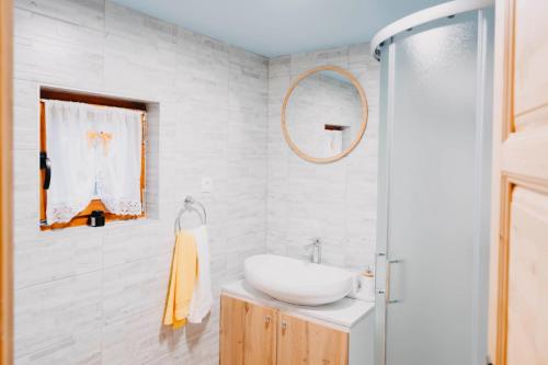 a white bathroom with a sink and a mirror at Turističko naselje MOSLAVAČKA DOLINA by Irundo in Velika Ludina
