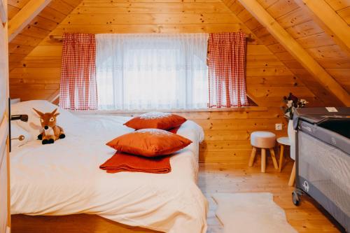 a bedroom with a bed in a wooden cabin at Turističko naselje MOSLAVAČKA DOLINA by Irundo in Velika Ludina