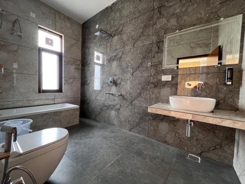 a bathroom with a sink and a toilet and a mirror at AeroVale Lodge I Mountain View Stay Near Landing Site Bir Billing in Bīr