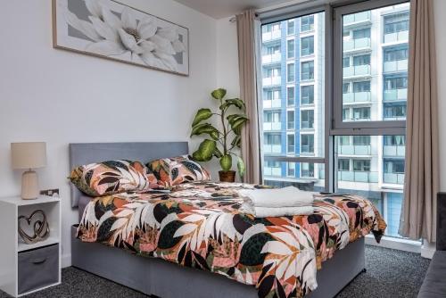 a bedroom with a bed and a large window at Stratford Central Apartment in London