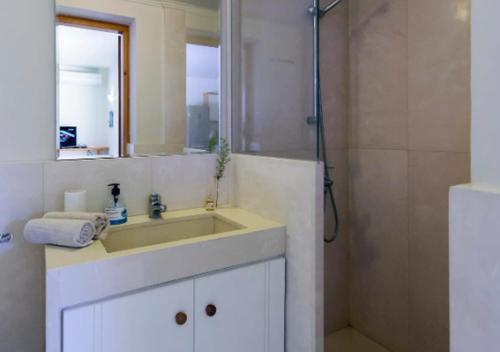 a white bathroom with a sink and a shower at Seaside Aqua Bliss & Serenity with Private Pool in Kranidi