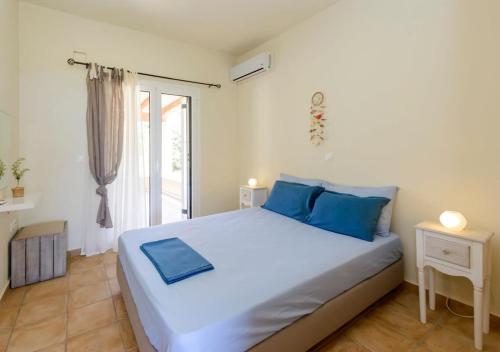 a bedroom with a large white bed with blue pillows at Seaside Aqua Bliss & Serenity with Private Pool in Kranidi