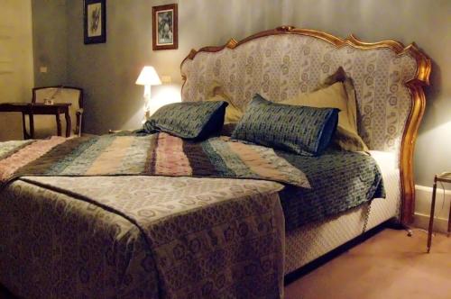 a bedroom with a large bed with blue pillows at Château Mesny in Vic-sur-Seille