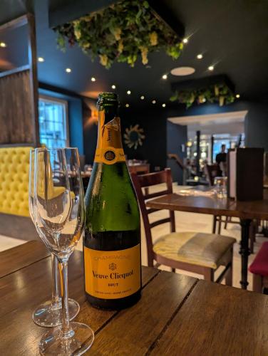 a bottle of wine and a wine glass on a table at Plato's in Kirkby Lonsdale
