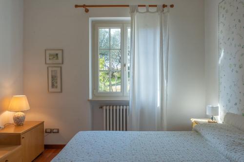 a bedroom with a bed and a window at Villa Panorama in Bardolino