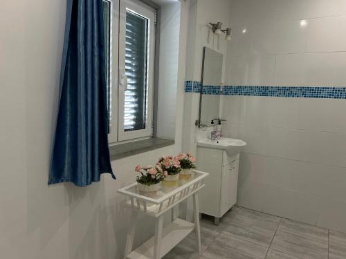a white bathroom with a sink and a mirror at Bing Garden Guesthouse in Lisbon