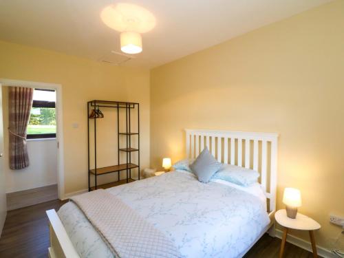 a bedroom with a white bed and two lamps at Thadg and Hannahs in Milltown
