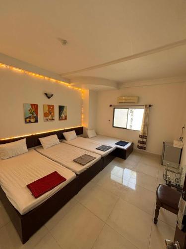a large bedroom with two beds and a window at Mai Guest House in Ho Chi Minh City