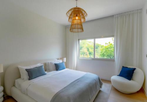 a white bedroom with a large bed and a window at Villa Mansour in Abu Dhabi
