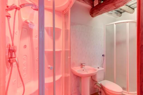 a pink bathroom with a sink and a shower at New Arcobaleno Ossegna in Maissana