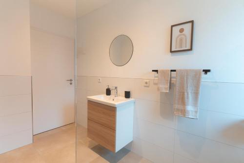 a white bathroom with a sink and a mirror at SeeZeit Einruhr in Simmerath