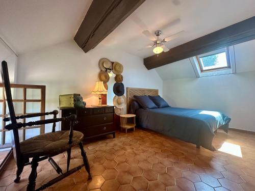 a bedroom with a bed and a chair in it at La Floraison in Molesmes