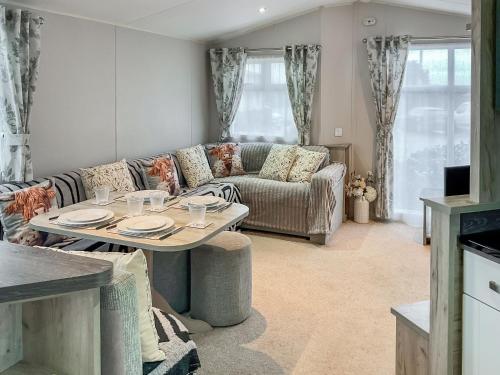 a living room with a table and a couch at 54 Beach Retreat in Burnham on Sea
