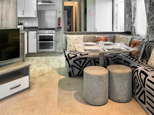 a living room with a couch and a table and a television at 54 Beach Retreat in Burnham on Sea