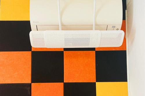 a white router on an orange black and colorful floor at Vicino Aeroporto - Orange Marina Room in Olbia