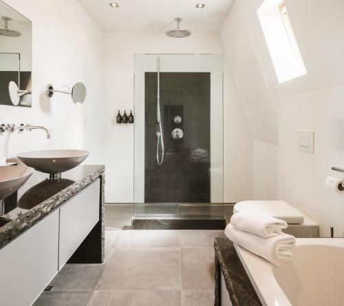 a bathroom with a tub and a sink at Strandhotel Domburg in Domburg
