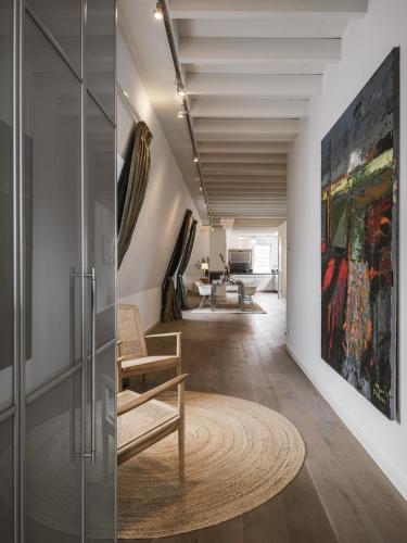 a hallway with a chair and a painting on the wall at Strandhotel Domburg in Domburg