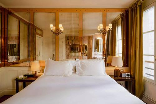a bedroom with a large bed with white pillows at Hôtel Amour Paris in Paris