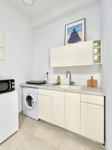 a kitchen with a sink and a washing machine at Nachlaot Gem - Bright, Central and Cozy in Jerusalem
