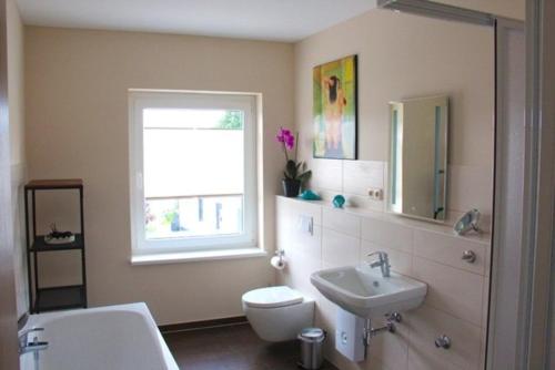 a bathroom with a sink and a toilet and a window at Am Wiesenblick 2 Pers in Röbel
