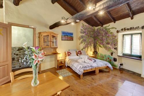 a bedroom with a bed and a vase of flowers on a table at New Arcobaleno Ossegna in Maissana