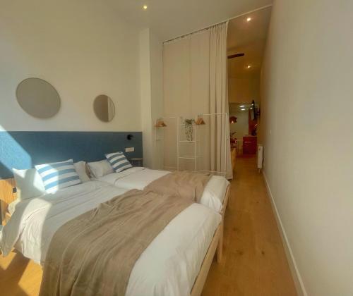 a bedroom with two beds and a blue and white wall at Bosko Etxea Apartamentos in Bilbao