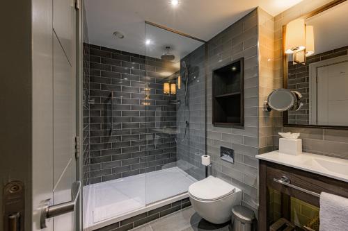 a bathroom with a shower and a toilet and a sink at Dakota Manchester in Manchester