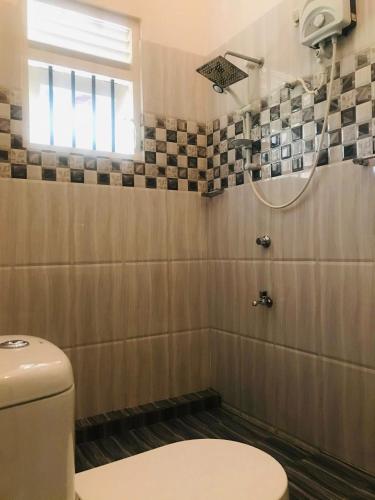 a bathroom with a toilet and a shower at Villa Shanthi in Dharga Town