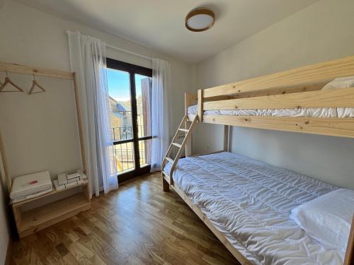 a bedroom with a bunk bed and a large window at Casa Miradell in Hoz de Jaca