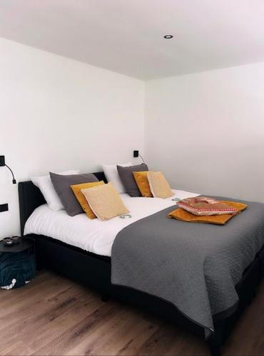 a large bed with pillows on it in a room at Het Blij Hoen in Oudenbosch
