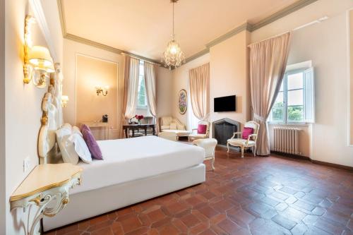 a bedroom with a large white bed and a living room at Art Hotel Villa Agape - Place of Charme in Florence