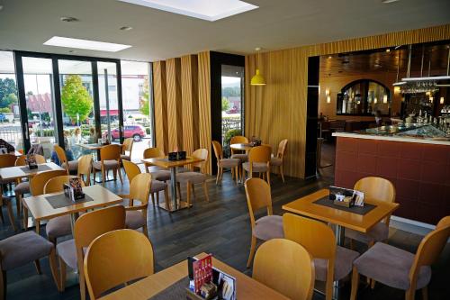 a restaurant with tables and chairs and a bar at Guest House Pohorska Kavarna in Maribor