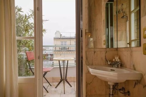 a bathroom with a sink and a view of a balcony at Hôtel Amour Paris in Paris
