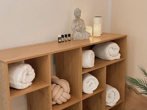 a wooden shelf with towels and a statue on it at Fewo Wolke in Menslage