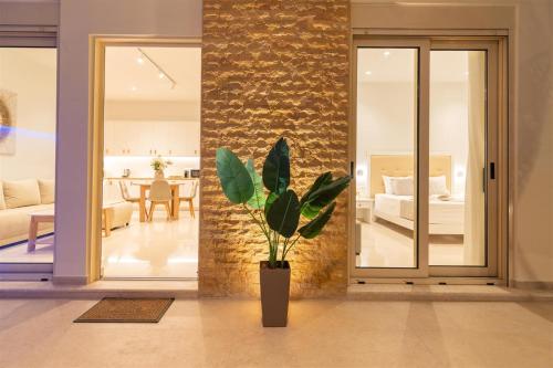 a living room with a potted plant and a bedroom at Nerida Luxury Villas in Kastéllion