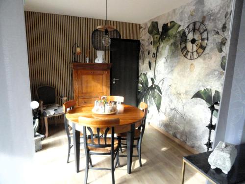 a dining room with a wooden table and chairs at CHAMBRES D'HÔTES LASSAY'rénité in Lassay