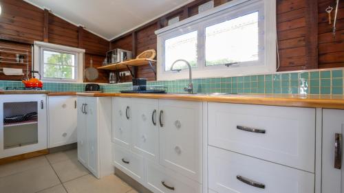 a kitchen with white cabinets and a sink at Traka Cottages in Sedgefield