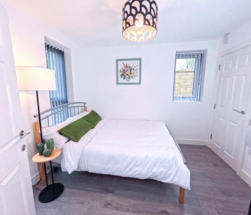 a white bedroom with a bed and a lamp at A- Modern En Suite Room Sheffield centre in Sheffield