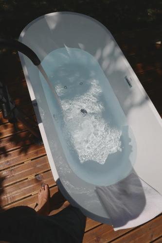a person sitting in a bath tub with a toilet at VILLA La Finca - Privada in Vieira do Minho