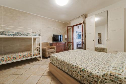 a bedroom with two bunk beds and a television at Casa Athena - Goelba in Portoferraio