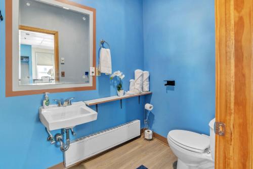 a blue bathroom with a toilet and a sink at Foothills Lodge & Cafe in Malone