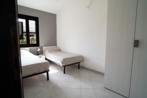 a room with two beds and a window at La Cinta Apartments in San Teodoro
