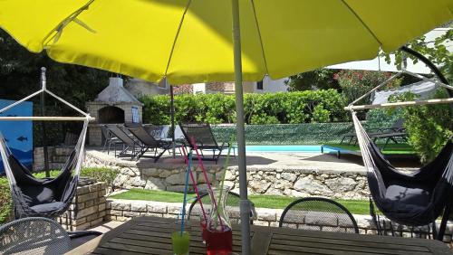 a patio with chairs and an umbrella and a pool at CENTRO POOL House in Novalja