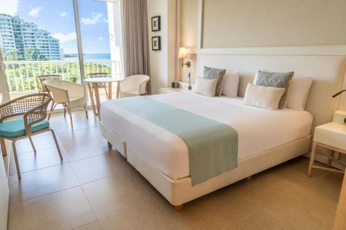 a hotel room with a large bed and a balcony at Hotel Irotama Lago in Santa Marta