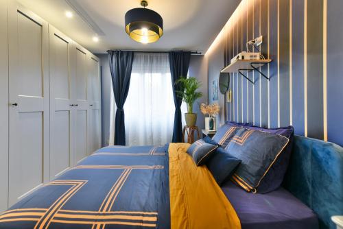 a bedroom with a blue and yellow bed and a window at Charmant appartement proche du centre de Nice in Nice
