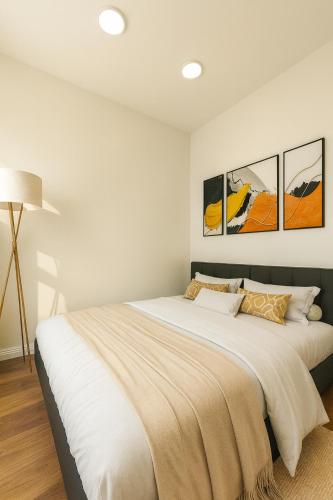 a bedroom with a large bed with three paintings on the wall at Urban Bloomsbury Hideaway in London