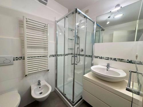 a bathroom with a toilet and a sink and a shower at Appartamento Tilatti in Grado
