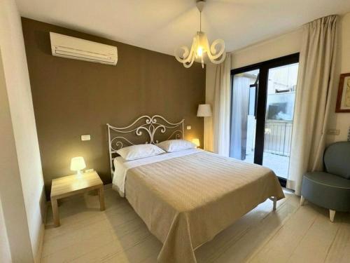 a bedroom with a bed and a chair and a window at Appartamento Tilatti in Grado