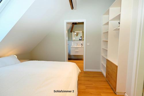 a bedroom with a white bed and a bathroom at Residenz R1 App 1 in Behrensdorf